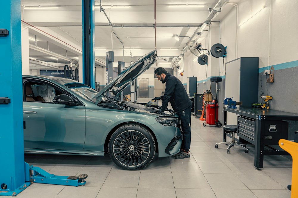 Mecánico revisando el motor de un coche en su taller